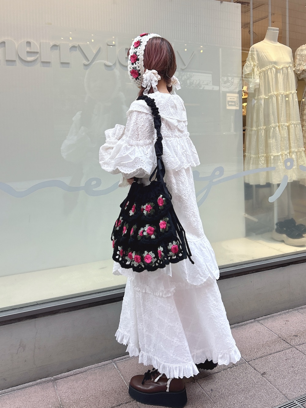 ホワイト系のテーラードジャケット、ホワイト系のスカート、ブラック系のショルダーバッグを着用したレディースの夏コーディネートの3枚目の写真