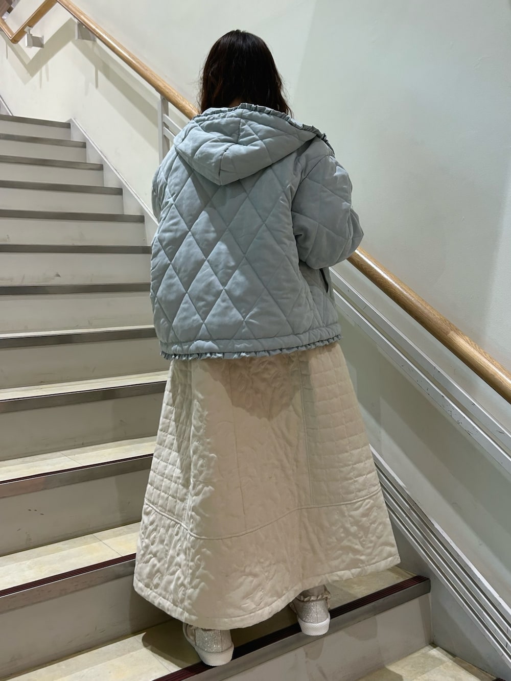 ピンク系のニット/セーター、ブルー系のダウンジャケット/コート、ホワイト系のワンピースを着用したレディースの冬コーディネートの3枚目の写真