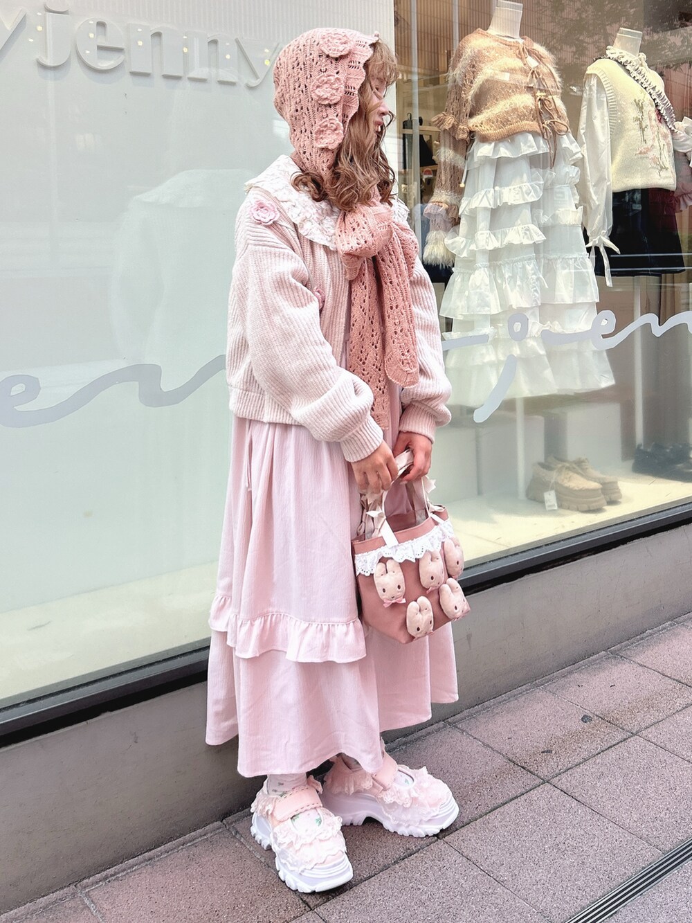 ピンク系のワンピース、ホワイト系のカーディガン/ボレロ、ピンク系のハンドバッグを着用したレディースの秋コーディネートの3枚目の写真