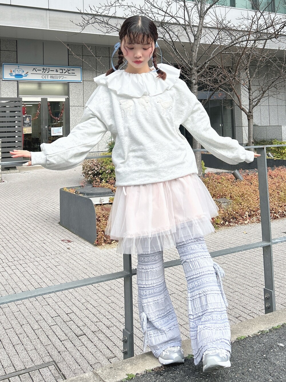 グレー系のスウェット、ピンク系のワンピース、ホワイト系のシャツ/ブラウスを着用したレディースの冬コーディネートの2枚目の写真