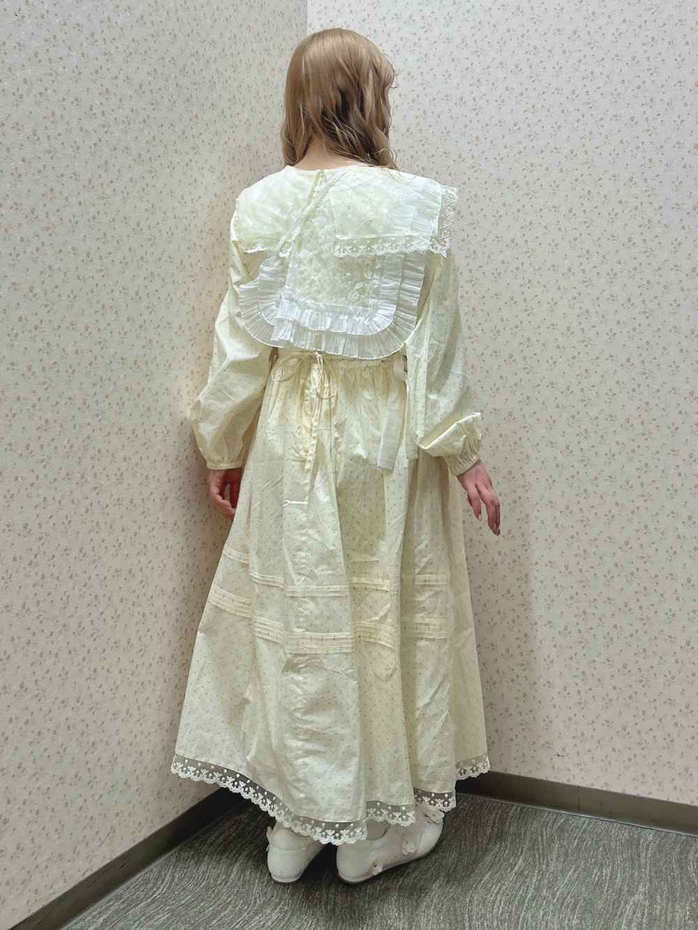 ベージュ系のワンピース、ホワイト系のハンドバッグ、ホワイト系のスニーカーを着用したレディースの冬コーディネートの4枚目の写真