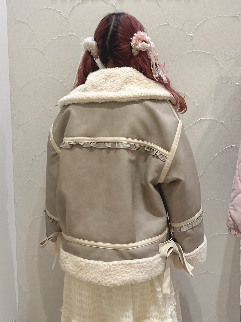 ホワイト系のシャツ/ブラウス、ホワイト系のベスト、ベージュ系のムートンコートを着用したレディースの冬コーディネートの6枚目の写真