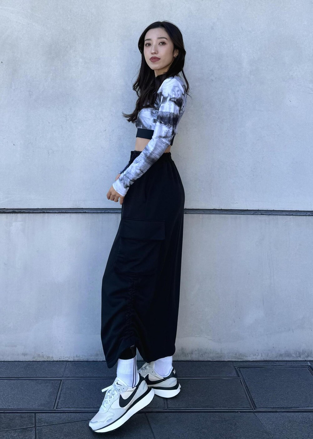 ブラック系のブルゾン、ブラック系のスカート、ホワイト系のスニーカーを着用したレディースの冬コーディネートの5枚目の写真