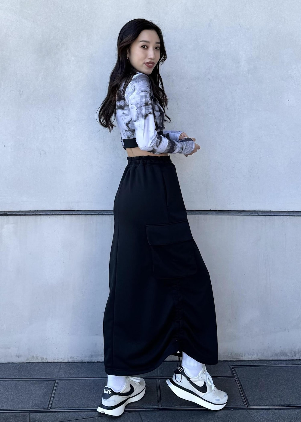 ブラック系のブルゾン、ブラック系のスカート、ホワイト系のスニーカーを着用したレディースの冬コーディネートの6枚目の写真