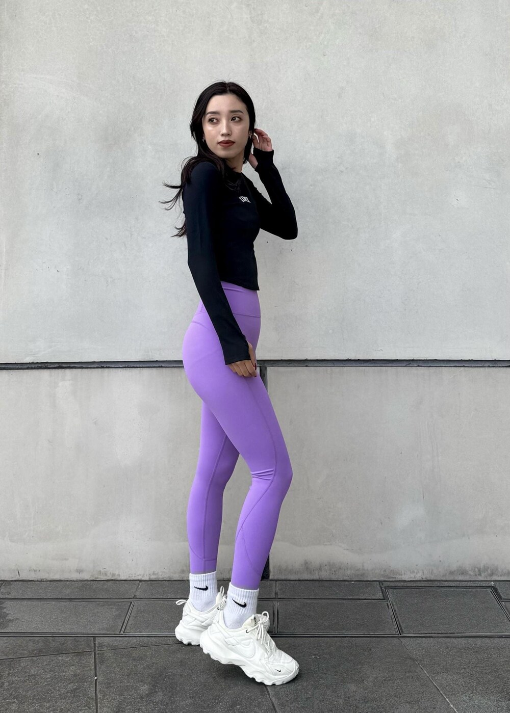 ホワイト系のスニーカー、ブラック系のダウンジャケット/コート、ブラック系のTシャツ/カットソーを着用したレディースの冬コーディネートの7枚目の写真