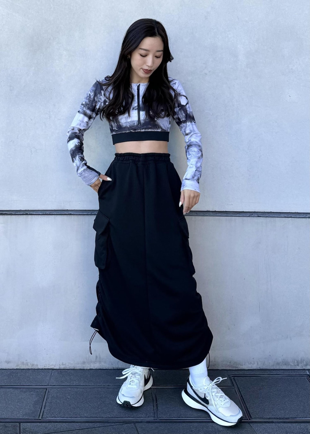 ブラック系のブルゾン、ブラック系のスカート、ホワイト系のスニーカーを着用したレディースの冬コーディネートの4枚目の写真