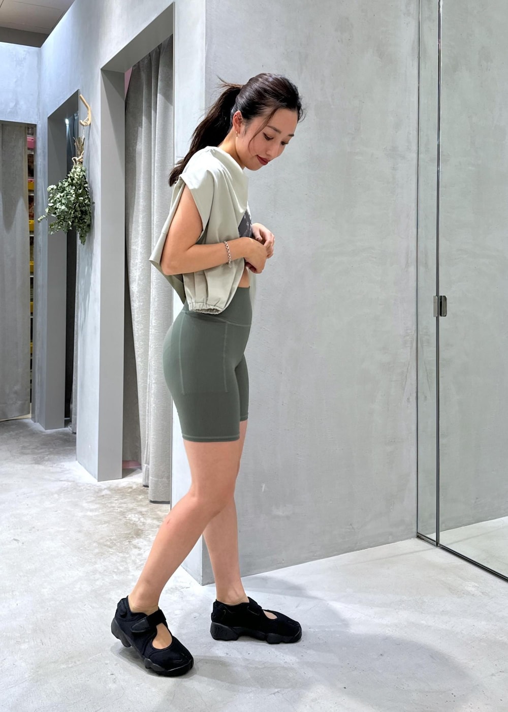 ブラック系のサンダル、グリーン系のラッシュガード、グリーン系のレギンス/スパッツを着用したレディースの夏コーディネートの4枚目の写真