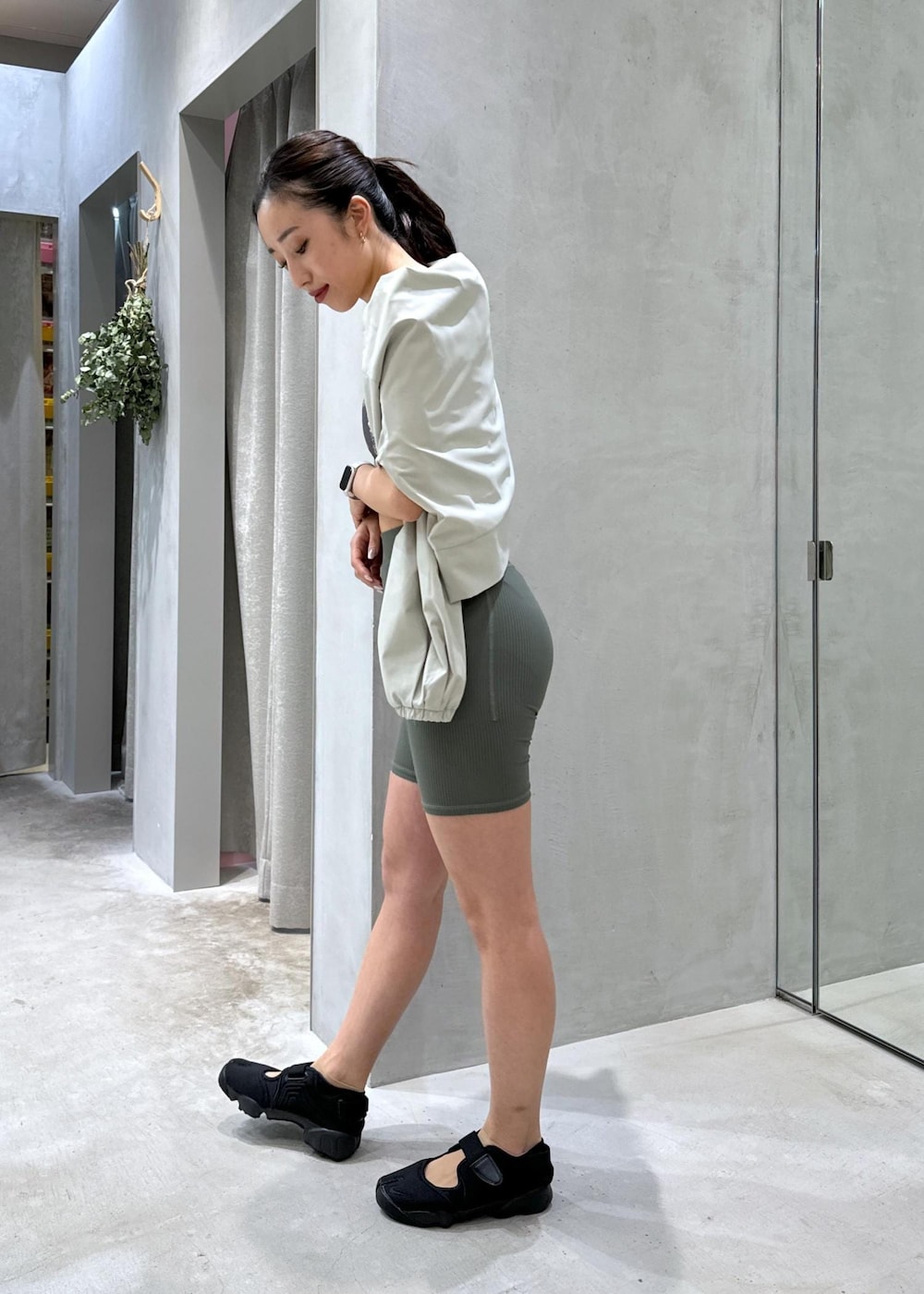 ブラック系のサンダル、グリーン系のラッシュガード、グリーン系のレギンス/スパッツを着用したレディースの夏コーディネートの2枚目の写真