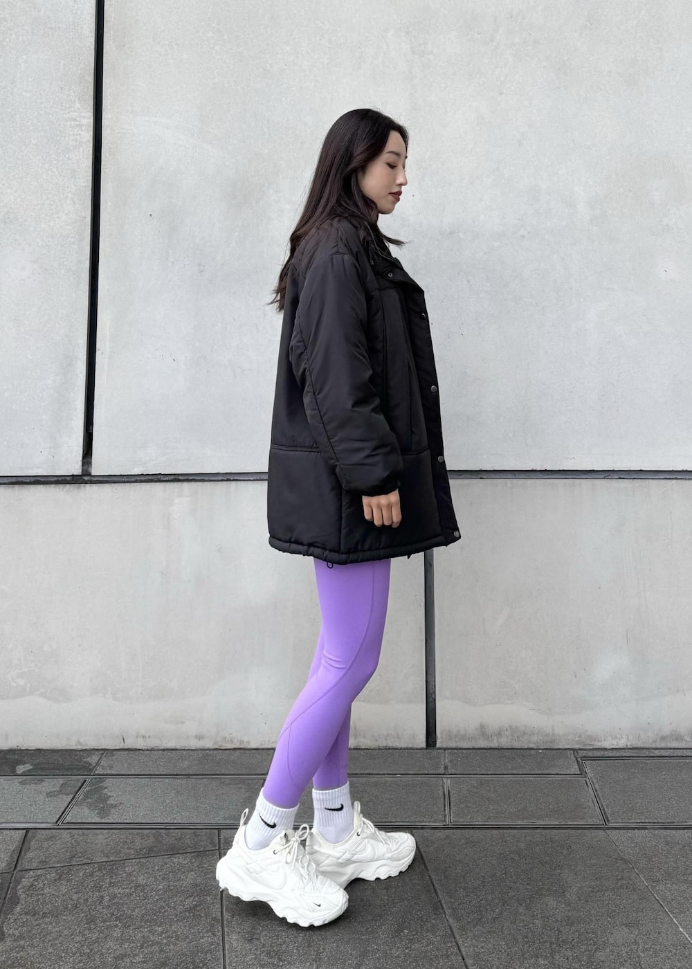 ホワイト系のスニーカー、ブラック系のダウンジャケット/コート、ブラック系のTシャツ/カットソーを着用したレディースの冬コーディネートの3枚目の写真