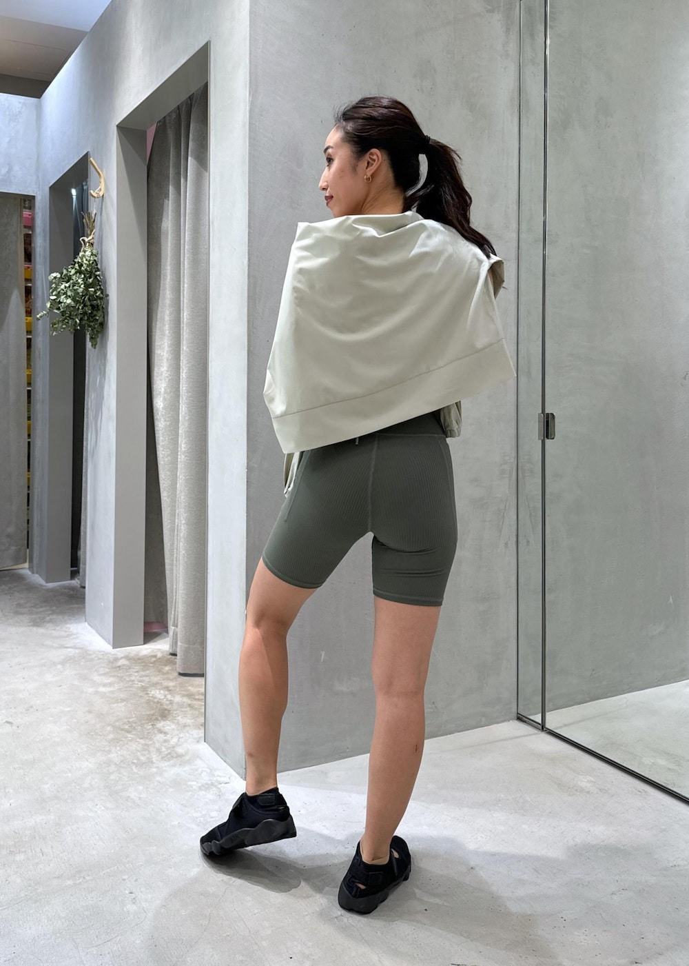 ブラック系のサンダル、グリーン系のラッシュガード、グリーン系のレギンス/スパッツを着用したレディースの夏コーディネートの3枚目の写真