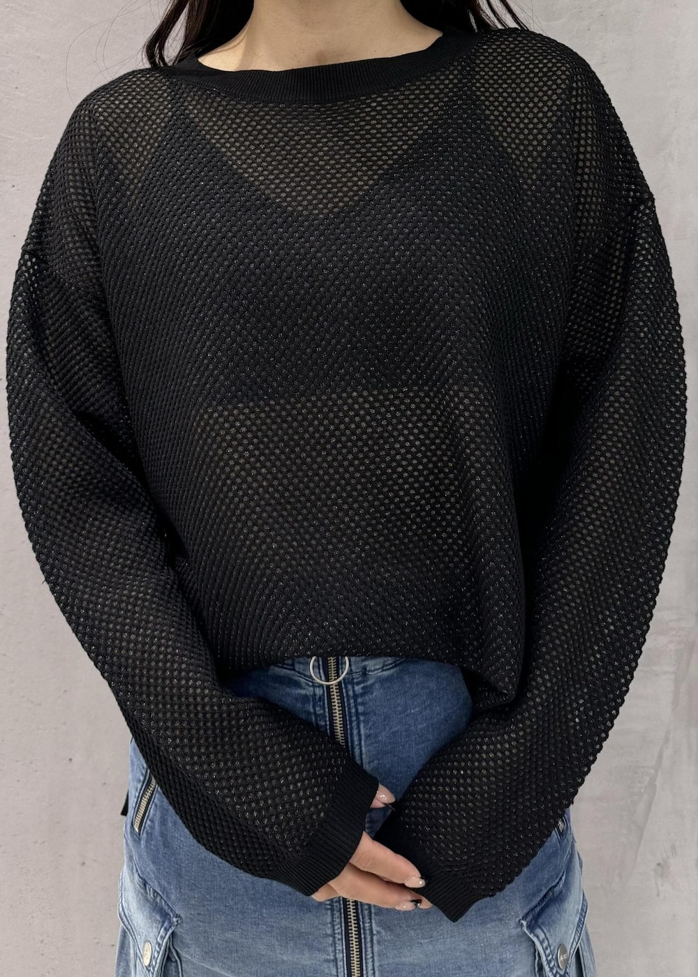 ブラック系のスニーカー、ブラック系のTシャツ/カットソー、ブルー系のデニムスカートを着用したレディースの春コーディネートの3枚目の写真