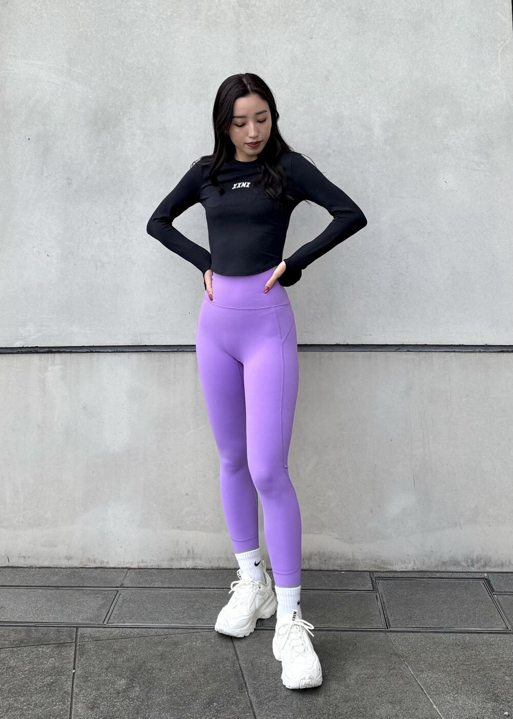 ホワイト系のスニーカー、ブラック系のダウンジャケット/コート、ブラック系のTシャツ/カットソーを着用したレディースの冬コーディネートの5枚目の写真