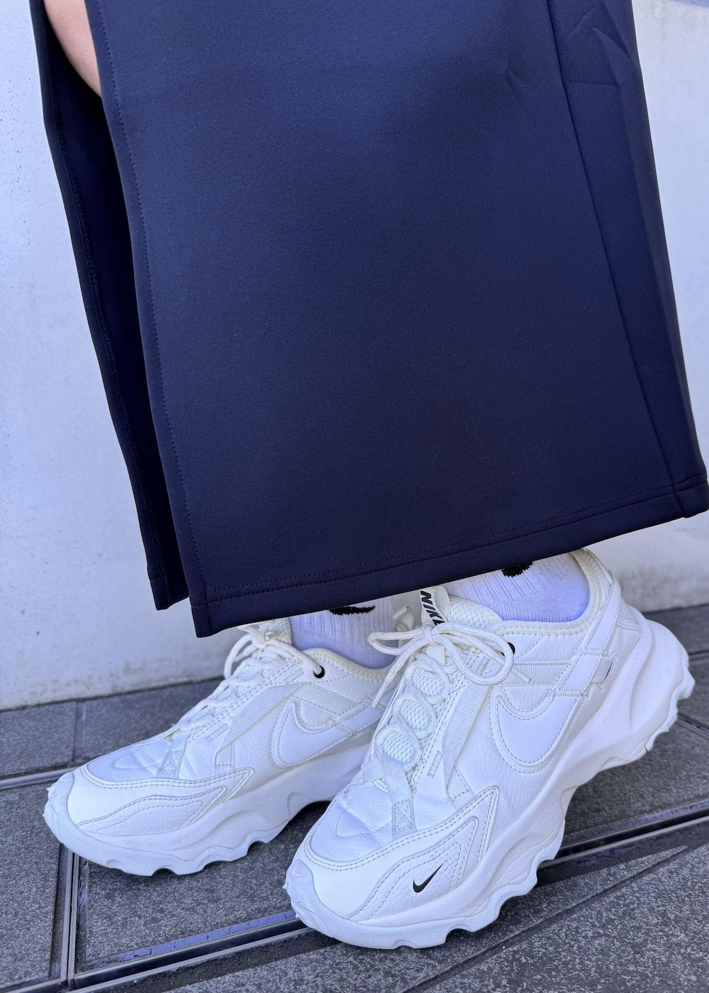 ブラック系のボディバッグ/ウエストポーチ、ホワイト系のカーディガン/ボレロ、ホワイト系のスニーカーを着用したレディースの秋コーディネートの7枚目の写真