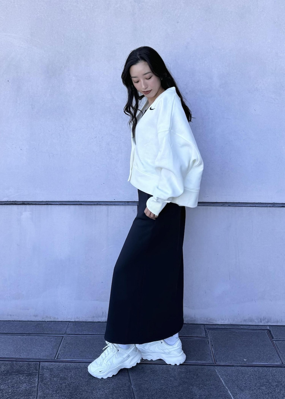 ブラック系のボディバッグ/ウエストポーチ、ホワイト系のカーディガン/ボレロ、ホワイト系のスニーカーを着用したレディースの秋コーディネートの3枚目の写真