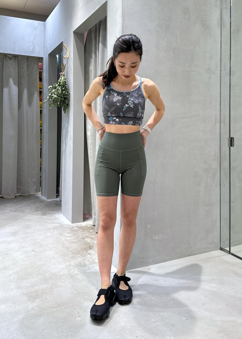 ブラック系のサンダル、グリーン系のラッシュガード、グリーン系のレギンス/スパッツを着用したレディースの夏コーディネートの5枚目の写真