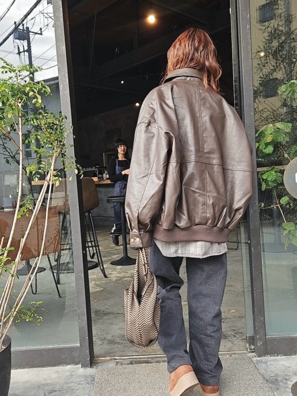 ブラウン系のブルゾン、ブラウン系のシャツ/ブラウス、ホワイト系のTシャツ/カットソーを着用したレディースの冬コーディネートの2枚目の写真