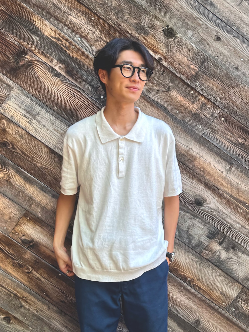 ホワイト系のポロシャツ、ブルー系のチノパンツ、ホワイト系のスニーカーを着用したメンズの夏コーディネートの2枚目の写真