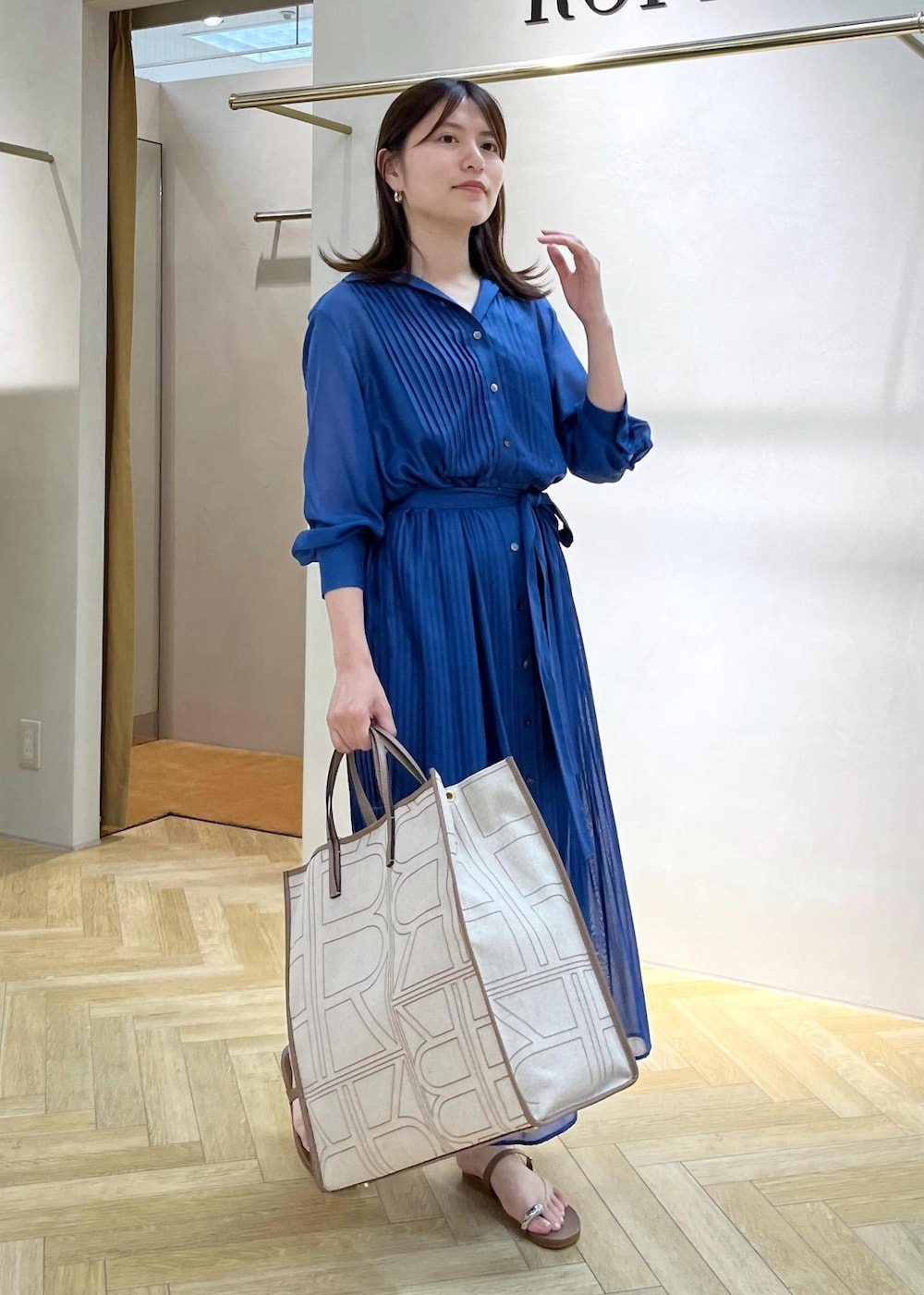 ベージュ系のサンダル、ブルー系のシャツワンピース、ベージュ系のトートバッグを着用したレディースの夏コーディネートの2枚目の写真