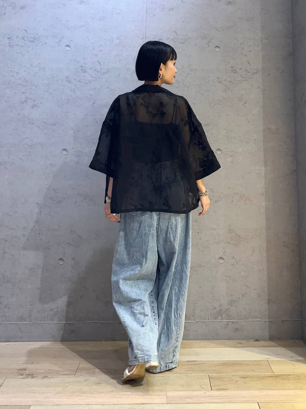 ブラック系のキャミソール、ブルー系のデニムパンツ、ブラック系のシャツ/ブラウスを着用したレディースの春コーディネートの3枚目の写真