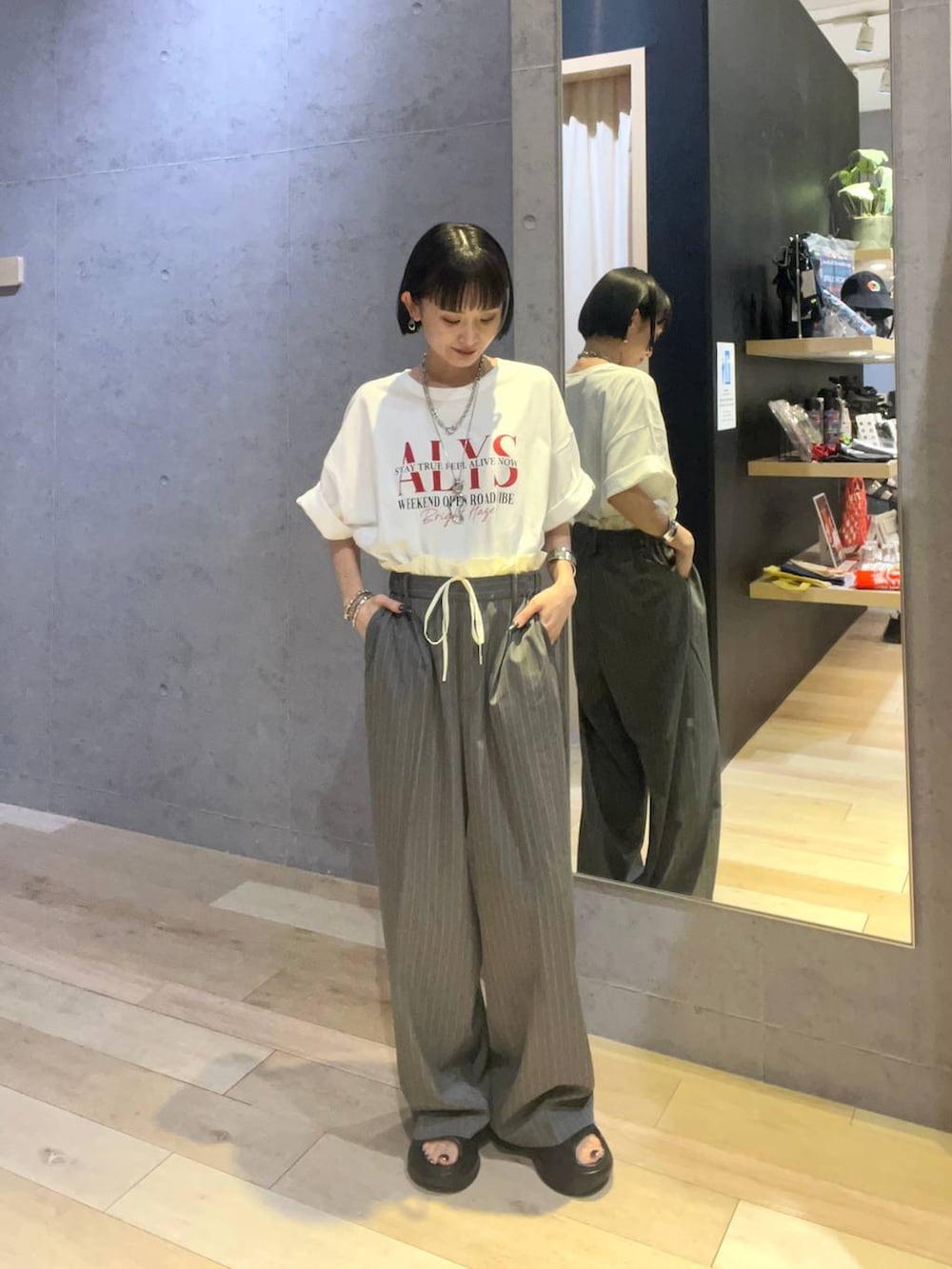 ホワイト系のTシャツ/カットソー、ブラック系のサンダル、その他のブレスレットを着用したレディースの夏コーディネートの2枚目の写真