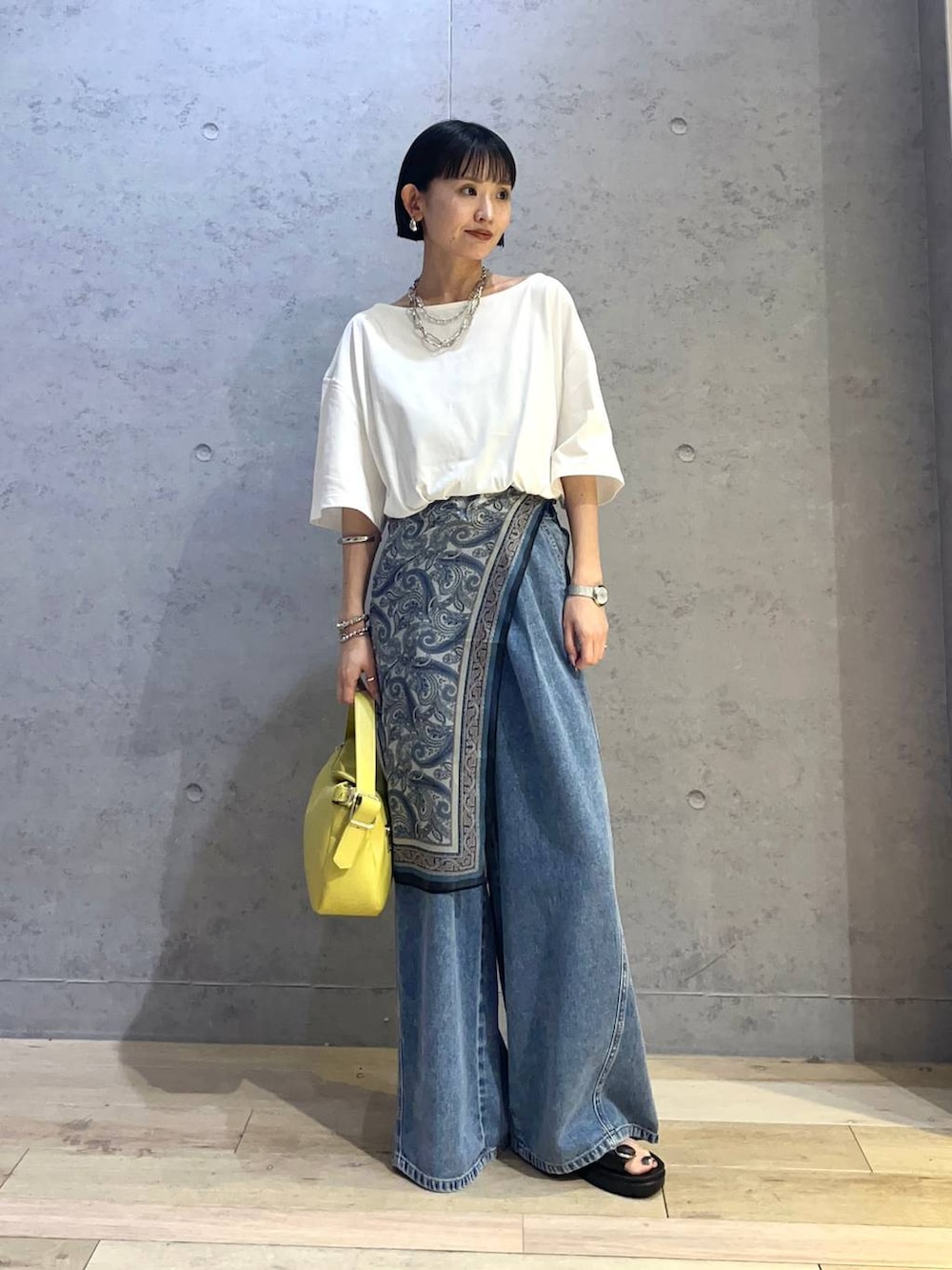 ホワイト系のTシャツ/カットソー、ブルー系のデニムパンツ、ブラック系のサンダルを着用したレディースの夏コーディネートの2枚目の写真