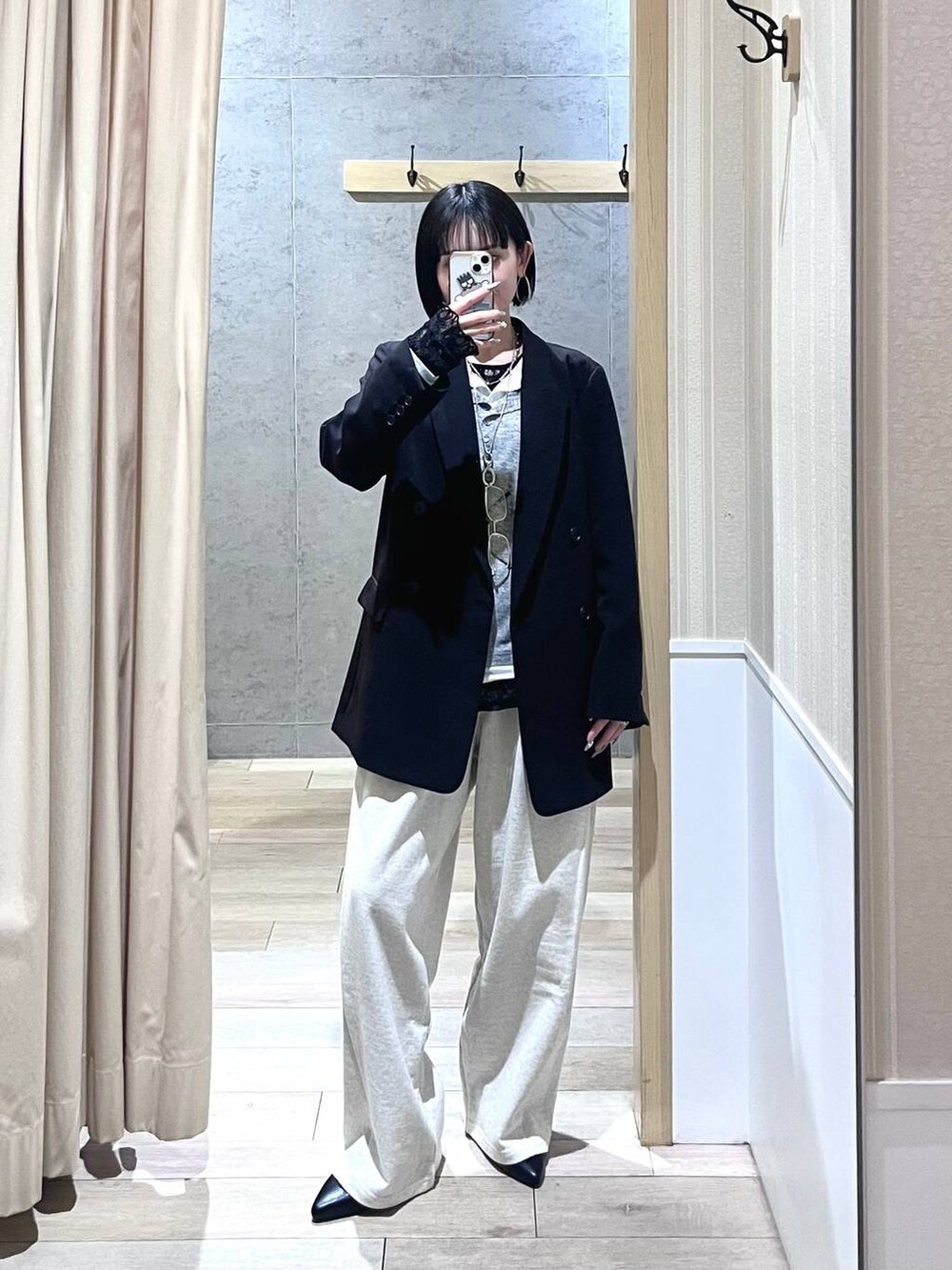 ブラック系のテーラードジャケット、ブラック系のパンプス、グレー系のTシャツ/カットソーを着用したレディースの冬コーディネートの2枚目の写真