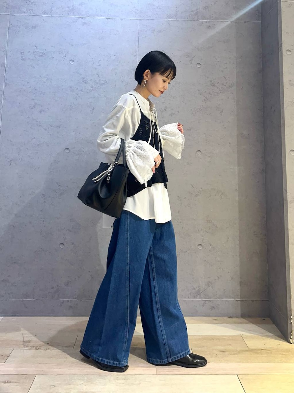 ブルー系のデニムパンツ、ホワイト系のシャツ/ブラウス、ブラック系のトートバッグを着用したレディースの冬コーディネートの2枚目の写真