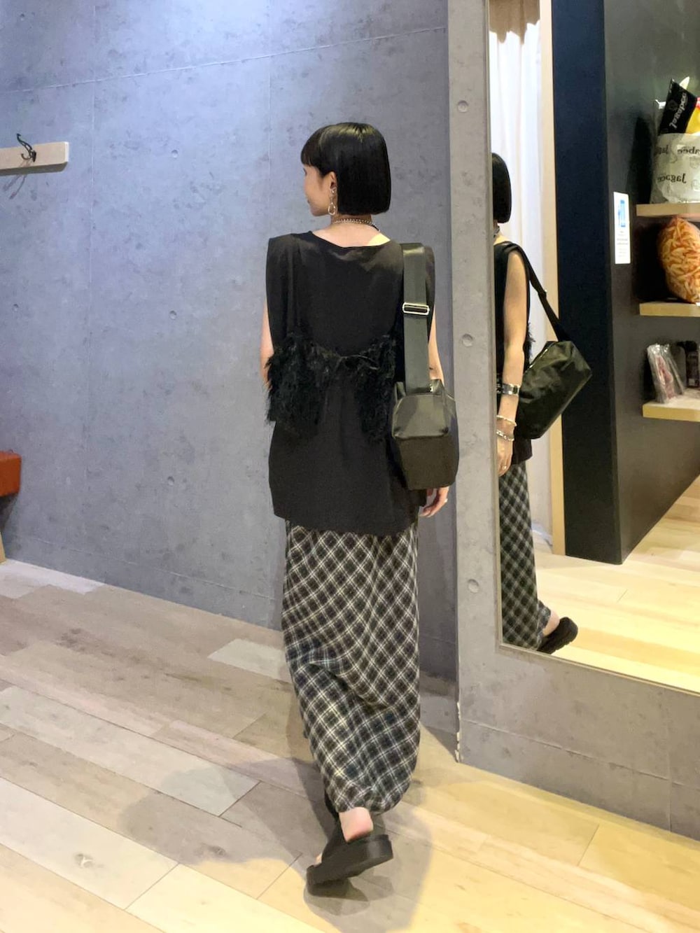ブラック系のショルダーバッグ、ブラック系のその他トップス、ブラック系のTシャツ/カットソーを着用したレディースの夏コーディネートの3枚目の写真