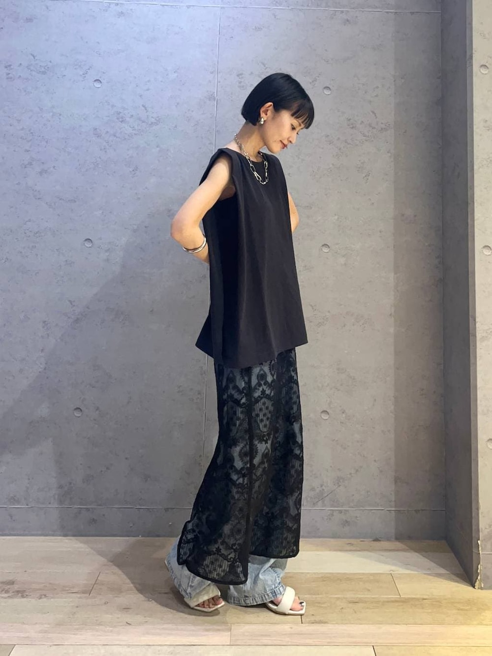 ブラック系のTシャツ/カットソー、ブラック系のスカート、ブルー系のデニムパンツを着用したレディースの夏コーディネートの2枚目の写真