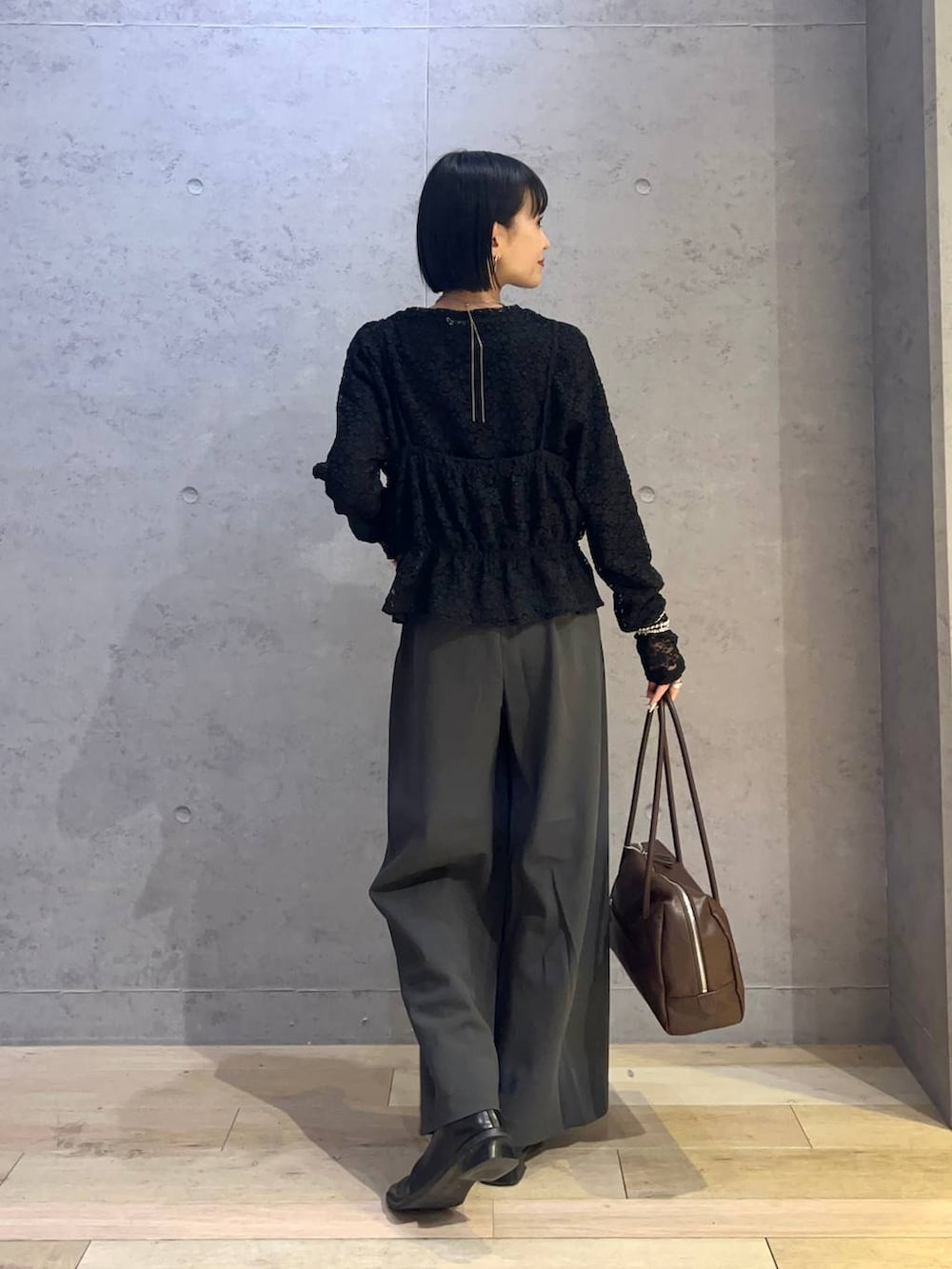 ブラウン系のボストンバッグ、グレー系のその他パンツを着用したレディースの春コーディネートの3枚目の写真