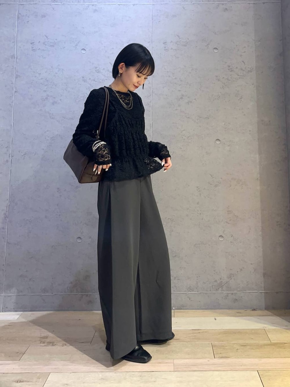 ブラウン系のボストンバッグ、グレー系のその他パンツを着用したレディースの春コーディネートの2枚目の写真