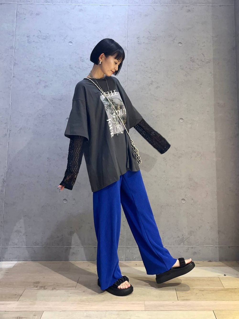 ブルー系のその他パンツ、ブラック系のサンダル、グレー系のTシャツ/カットソーを着用したレディースの春コーディネートの2枚目の写真