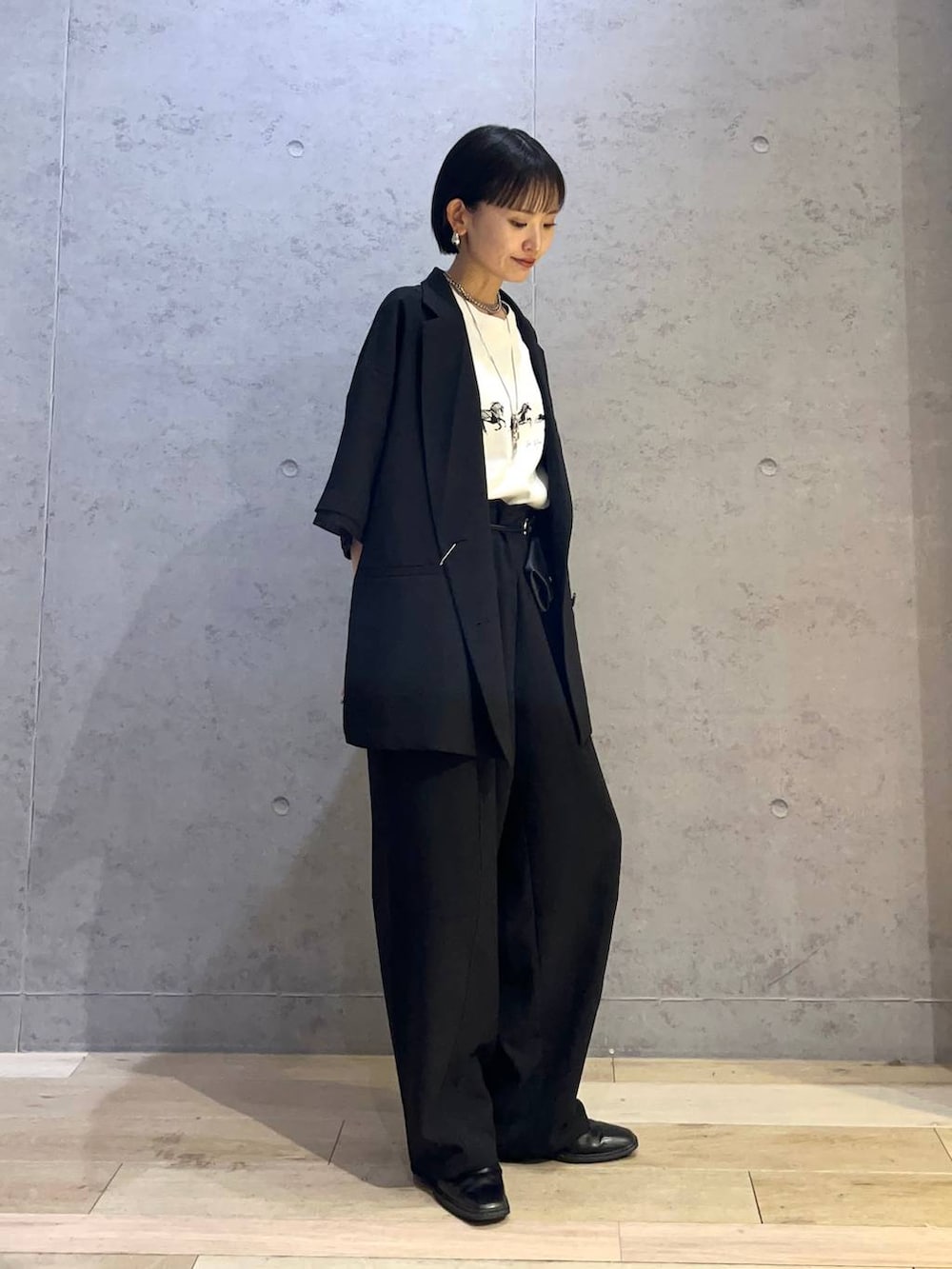 ブラック系のその他パンツ、ブラック系のテーラードジャケット、ブラック系のショルダーバッグを着用したレディースの春コーディネートの2枚目の写真