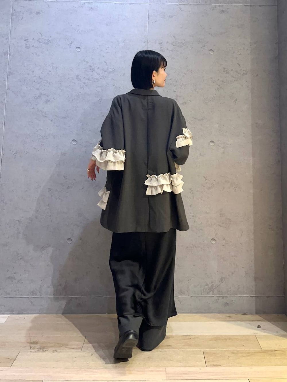 グレー系のその他パンツ、ブラック系のワンピース、シルバー系のネックレスを着用したレディースの冬コーディネートの3枚目の写真