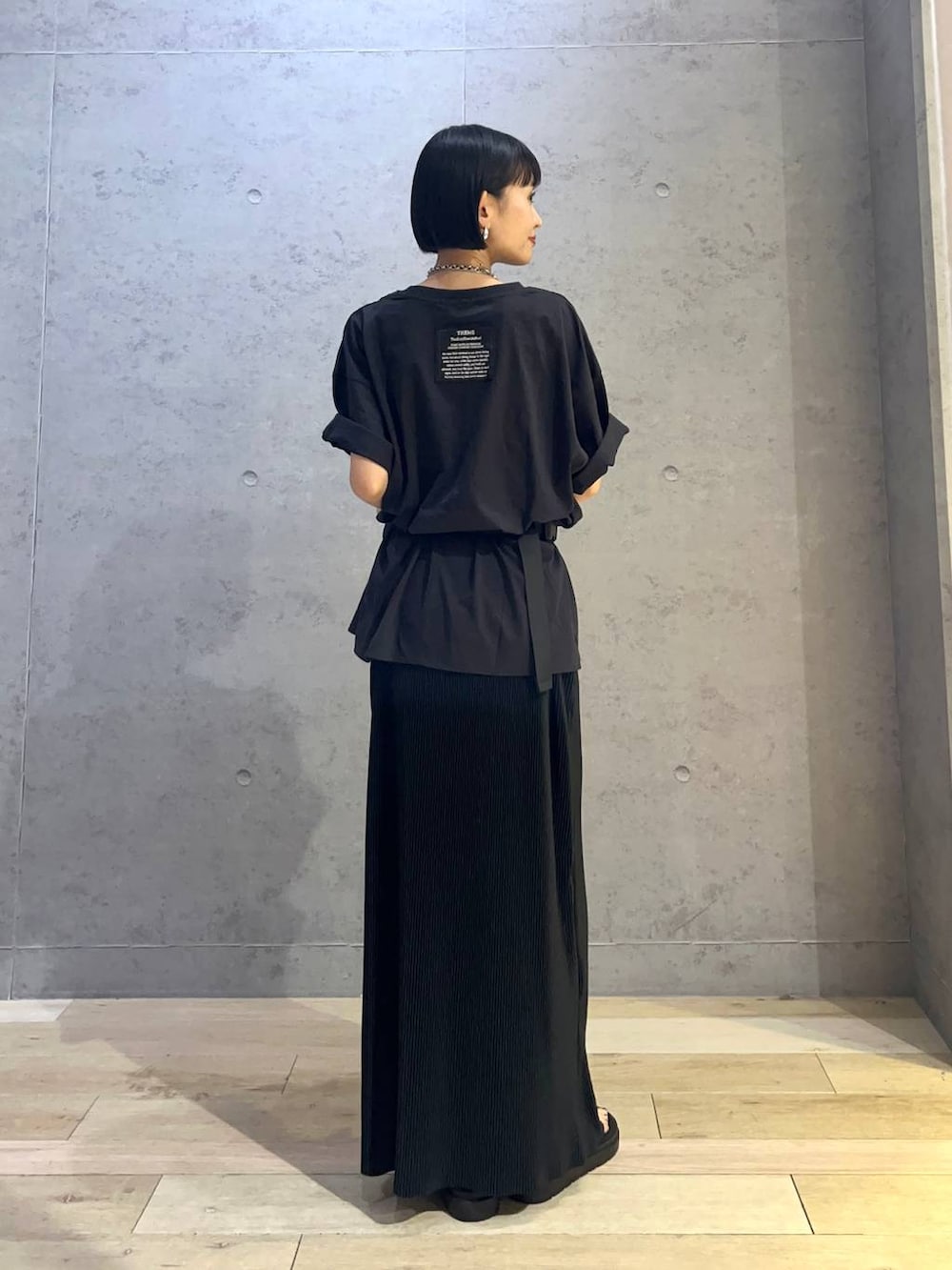 ブラック系のTシャツ/カットソー、ブラック系のサンダル、ブラック系のスカートを着用したレディースの夏コーディネートの3枚目の写真