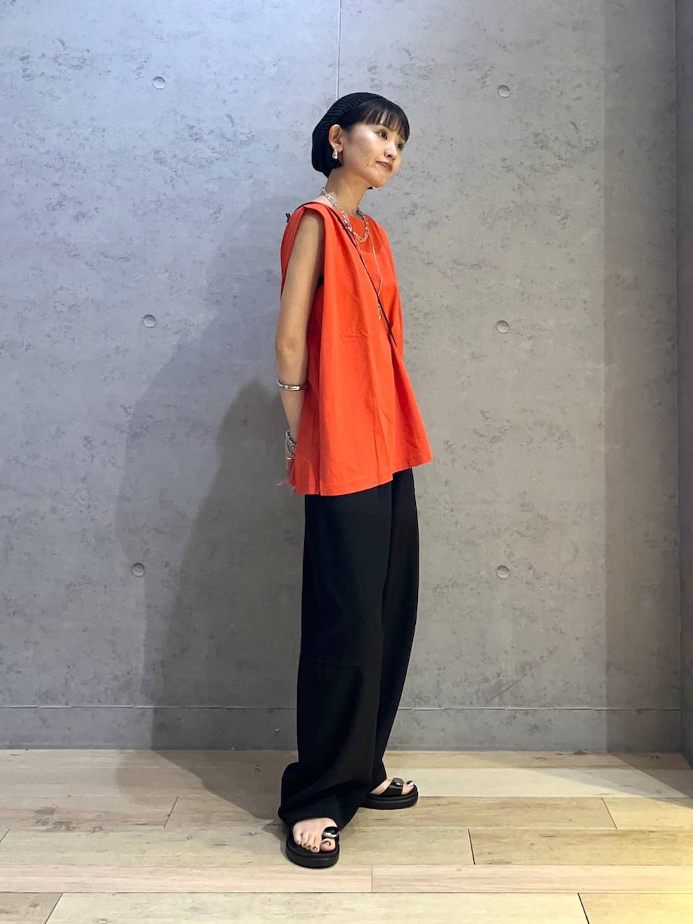 レッド系のTシャツ/カットソー、ブラック系のサンダル、ブラック系のその他パンツを着用したレディースの夏コーディネートの2枚目の写真