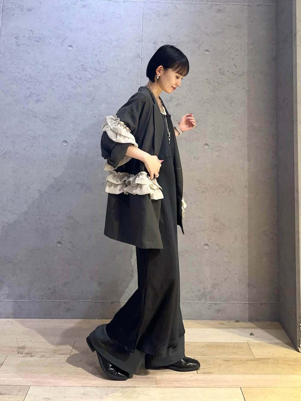 グレー系のその他パンツ、ブラック系のワンピース、シルバー系のネックレスを着用したレディースの冬コーディネートの2枚目の写真