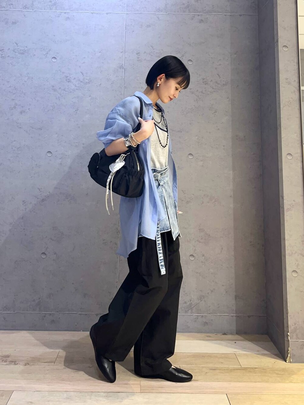ブルー系のシャツ/ブラウス、グレー系のTシャツ/カットソー、ブラック系のボストンバッグを着用したレディースの春コーディネートの2枚目の写真