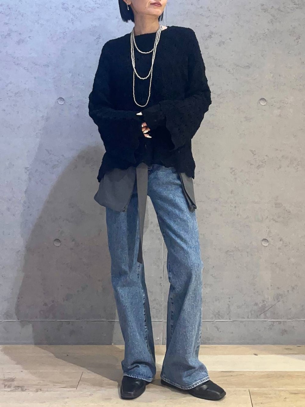 ブラック系のTシャツ/カットソー、ブラック系のニット/セーター、シルバー系のネックレスを着用したレディースの春コーディネートの3枚目の写真