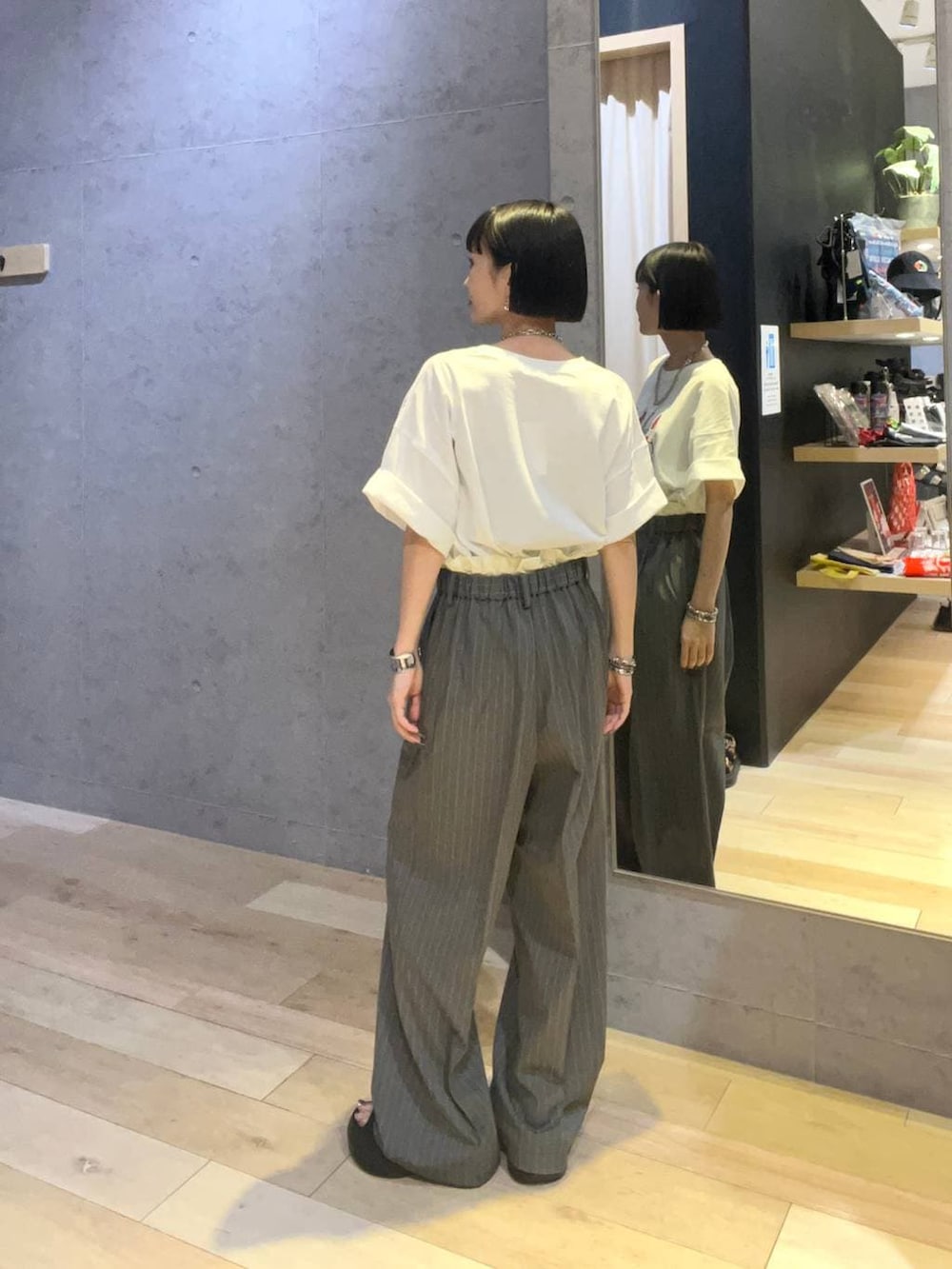 ホワイト系のTシャツ/カットソー、ブラック系のサンダル、その他のブレスレットを着用したレディースの夏コーディネートの3枚目の写真