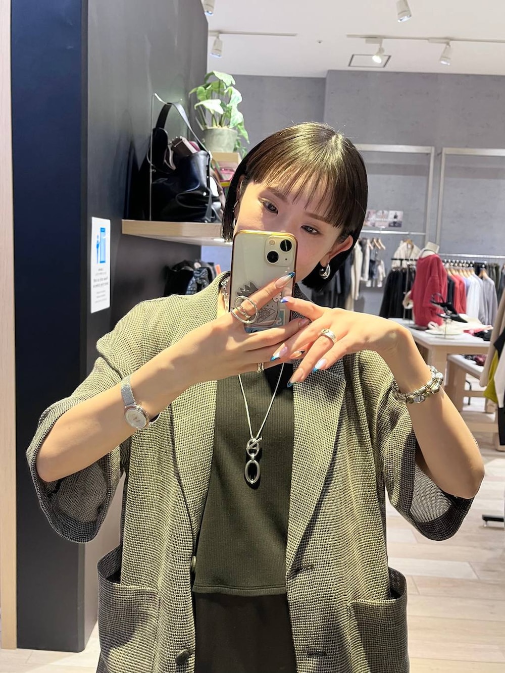 ブラック系のキャミソール、ブラック系のテーラードジャケット、ブルー系のデニムパンツを着用したレディースの春コーディネートの5枚目の写真