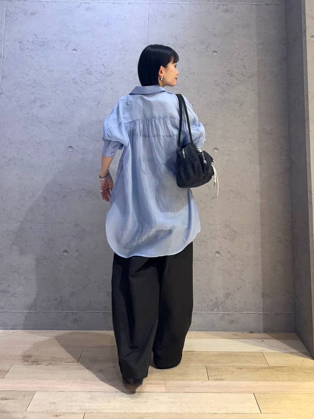 ブルー系のシャツ/ブラウス、グレー系のTシャツ/カットソー、ブラック系のボストンバッグを着用したレディースの春コーディネートの3枚目の写真