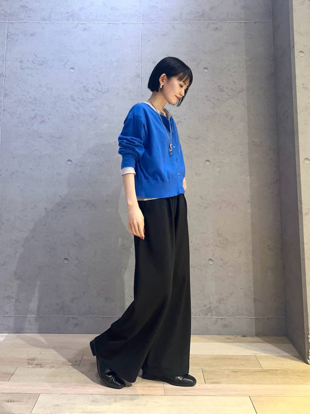 ブラック系のその他パンツ、ブルー系のカーディガン/ボレロ、シルバー系のネックレスを着用したレディースの冬コーディネートの2枚目の写真