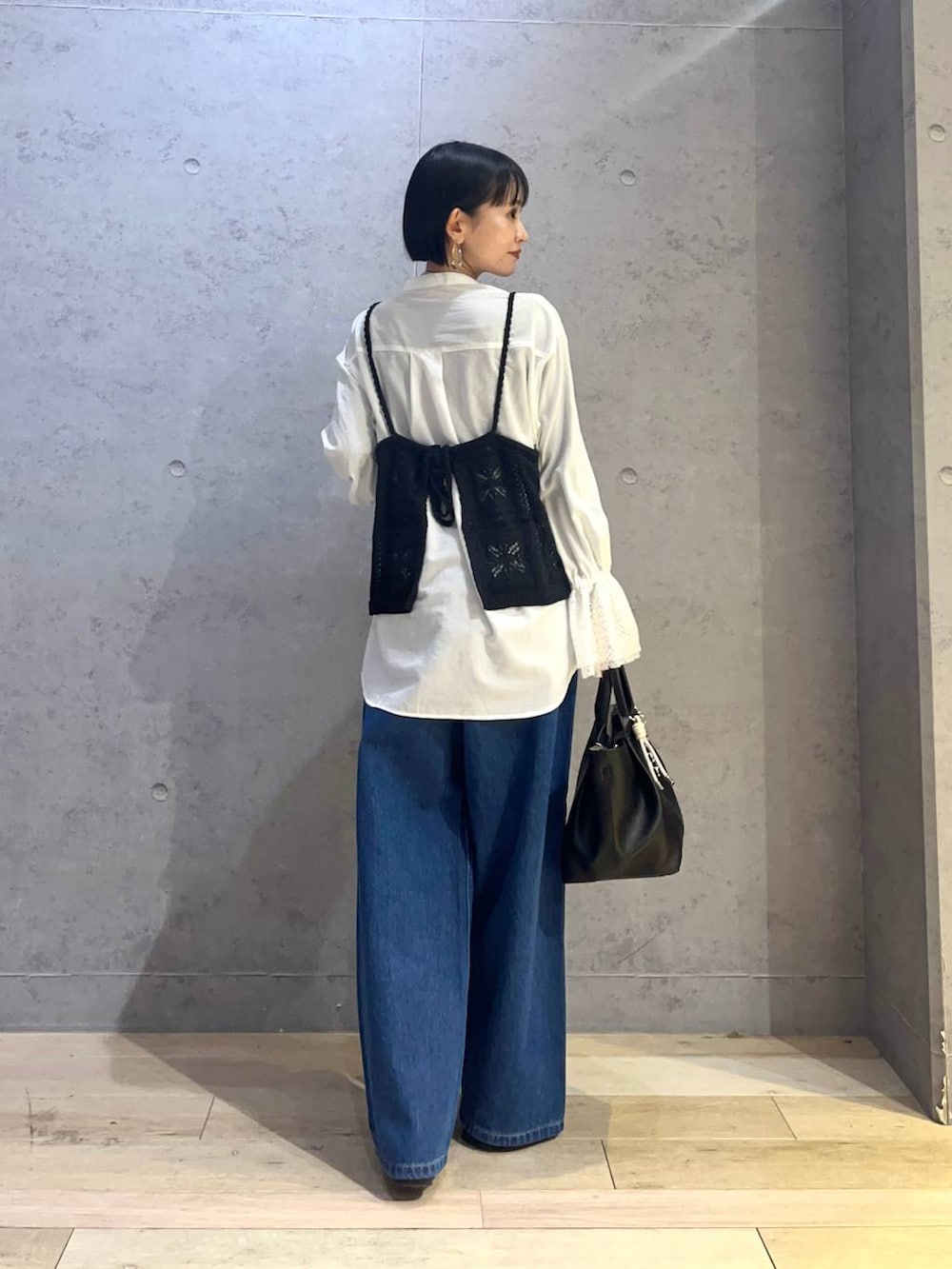 ブルー系のデニムパンツ、ホワイト系のシャツ/ブラウス、ブラック系のトートバッグを着用したレディースの冬コーディネートの3枚目の写真