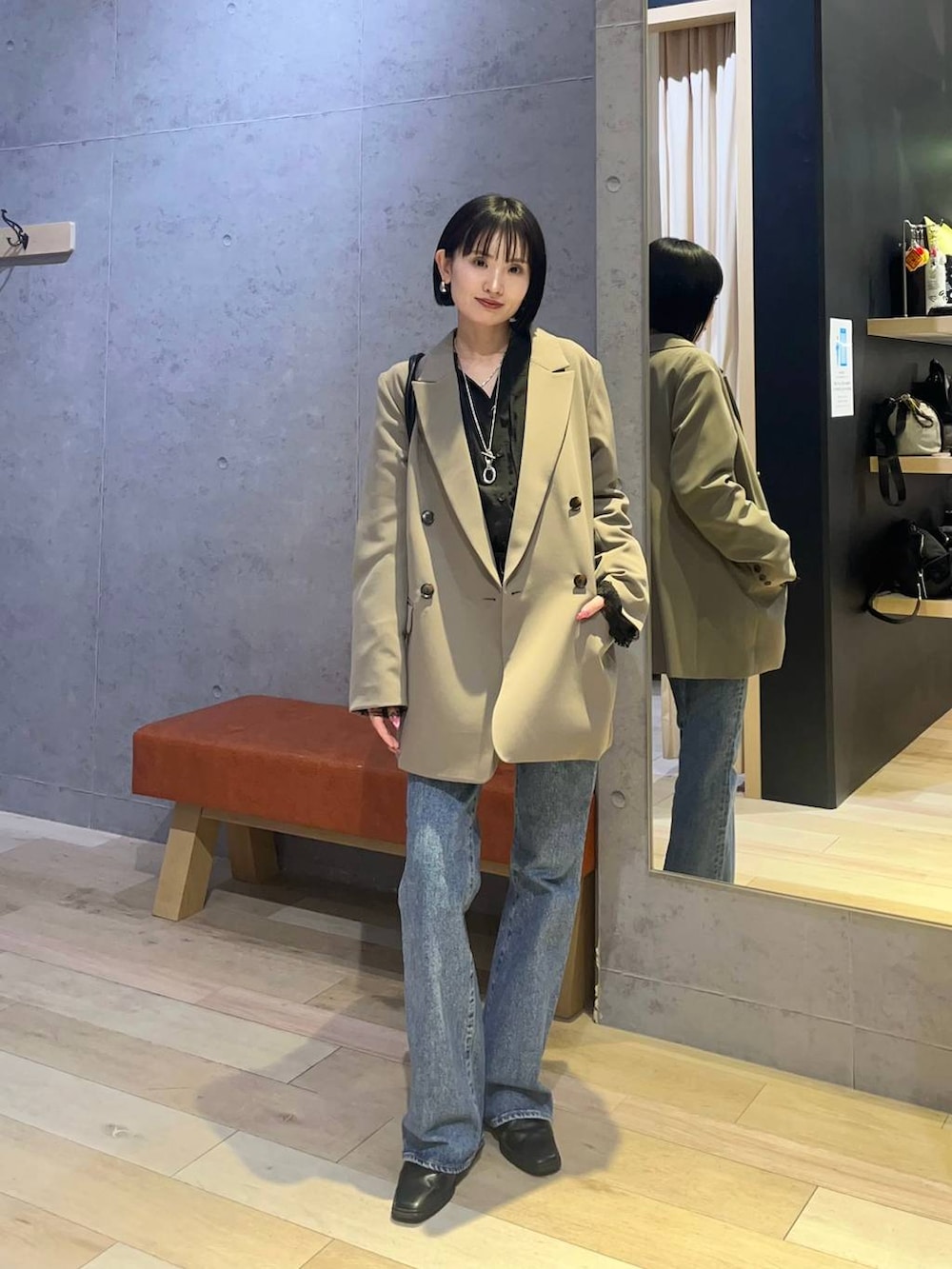 ブラウン系のテーラードジャケット、ブラック系のボストンバッグ、ブラック系のシャツ/ブラウスを着用したレディースの冬コーディネートの2枚目の写真