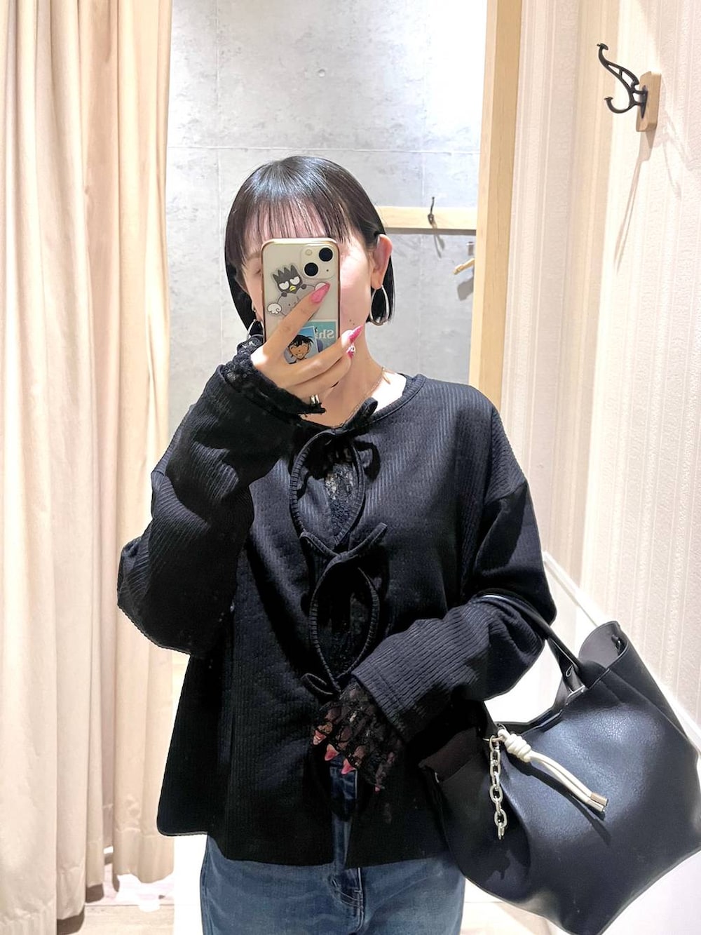 ブラック系のトートバッグ、ブルー系のデニムパンツ、ブラック系のTシャツ/カットソーを着用したレディースの冬コーディネートの2枚目の写真