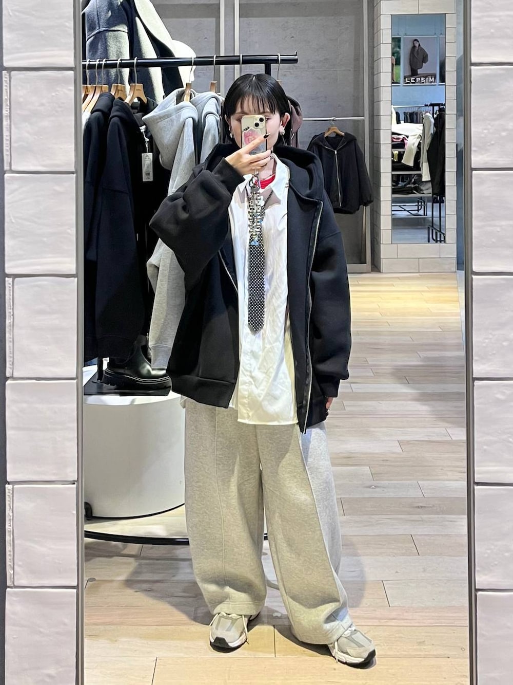 グレー系のスウェットパンツ、ホワイト系のシャツ/ブラウス、ブラック系のパーカーを着用したレディースの冬コーディネートの2枚目の写真