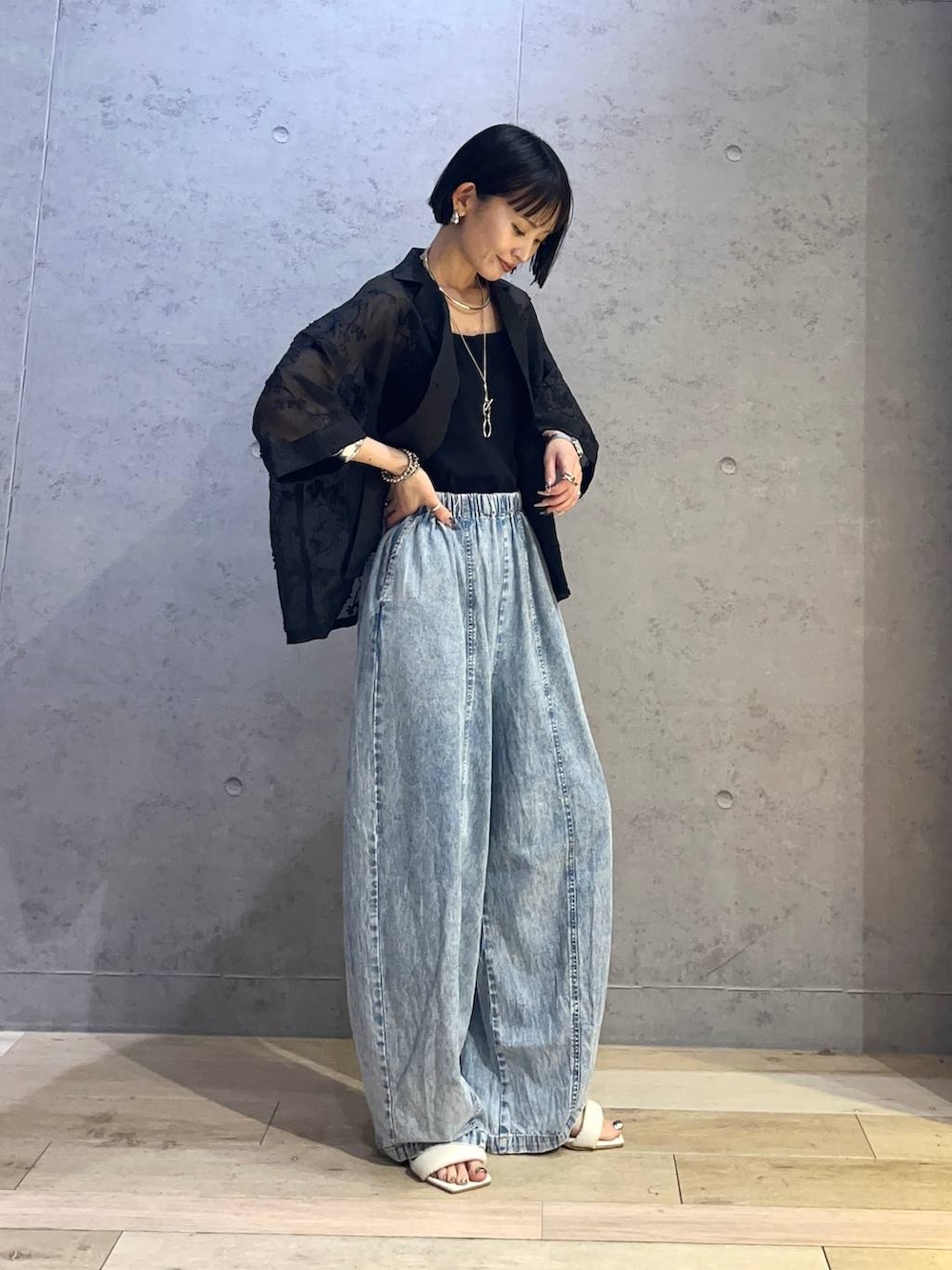 ブラック系のキャミソール、ブルー系のデニムパンツ、ブラック系のシャツ/ブラウスを着用したレディースの春コーディネートの2枚目の写真