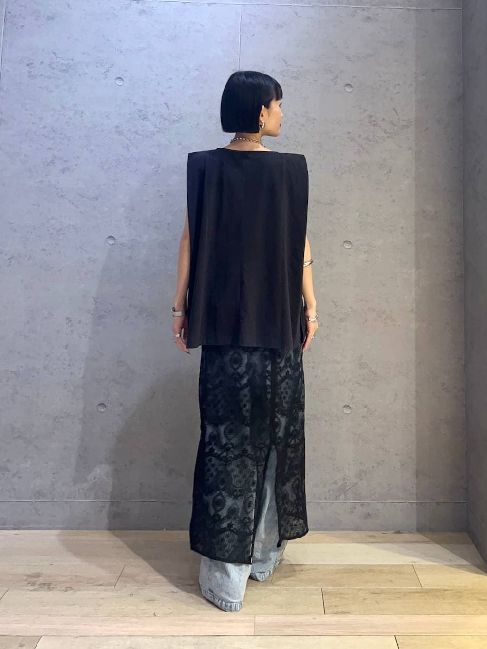 ブラック系のTシャツ/カットソー、ブラック系のスカート、ブルー系のデニムパンツを着用したレディースの夏コーディネートの3枚目の写真