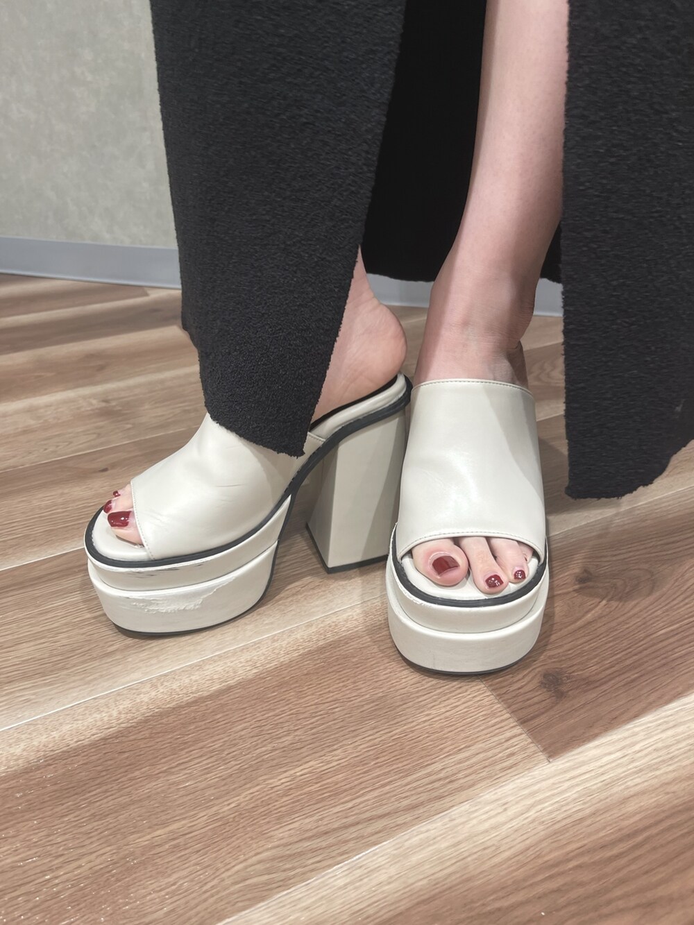 ブラック系のタンクトップ、ブラック系のスカート、グリーン系のハンドバッグを着用したレディースの夏コーディネートの6枚目の写真